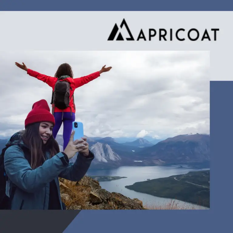 women taking selfie on mountain wearing Apricoat jackets